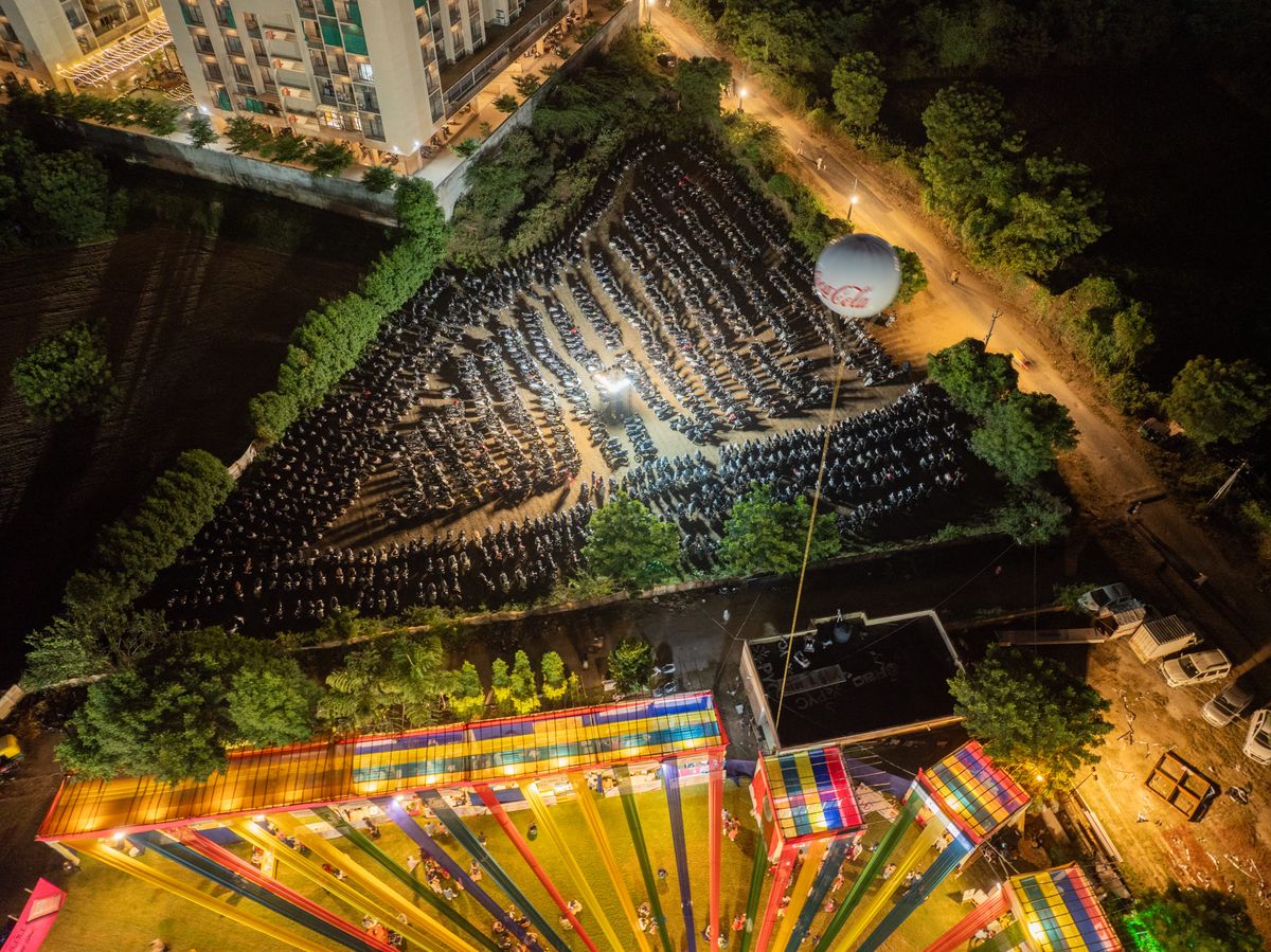 M K Farm house at night from above: the lit garba ground beside the parking field